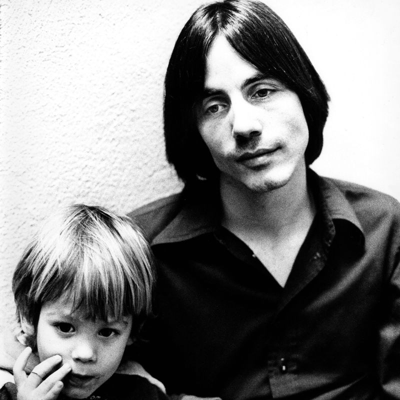 Jackson Browne posed with a child (possibly his son Ethan Zane) in Los Angeles in 1974