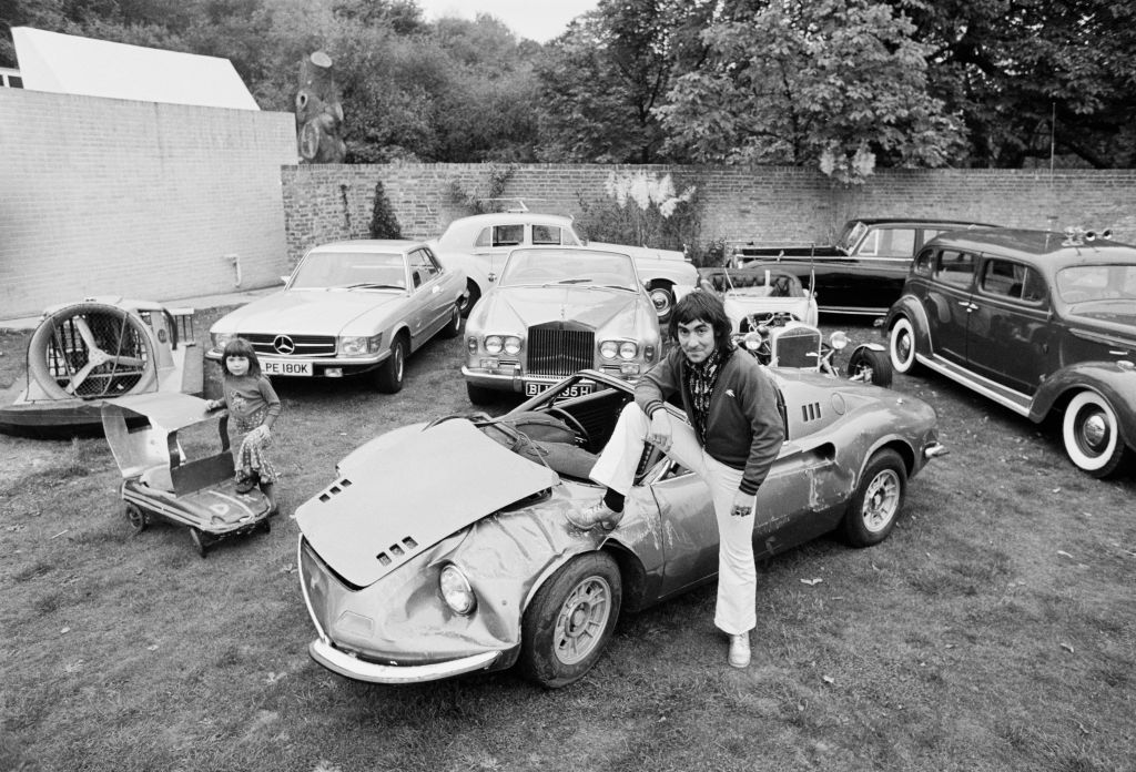 Keith Moon, drummer of The Who, at Tara, his home in Surrey, with his daughter Amanda and some of his cars