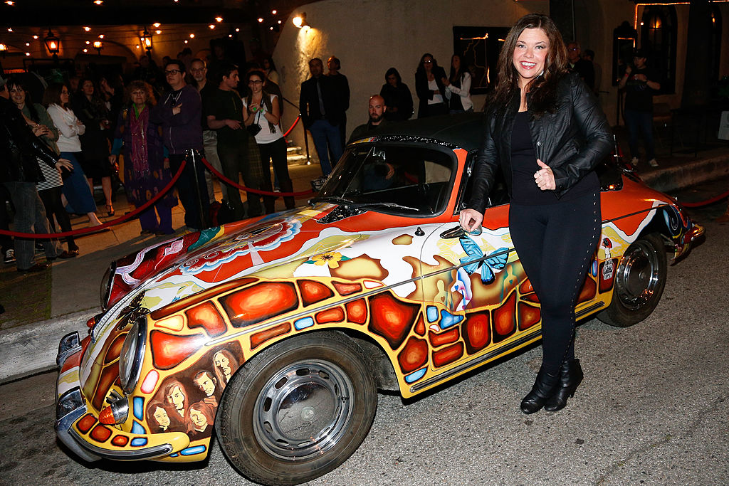 Actress Mary Bridget Davies next to Janis Joplin's hand-painted 1965 Porsche 356c Cabriolet