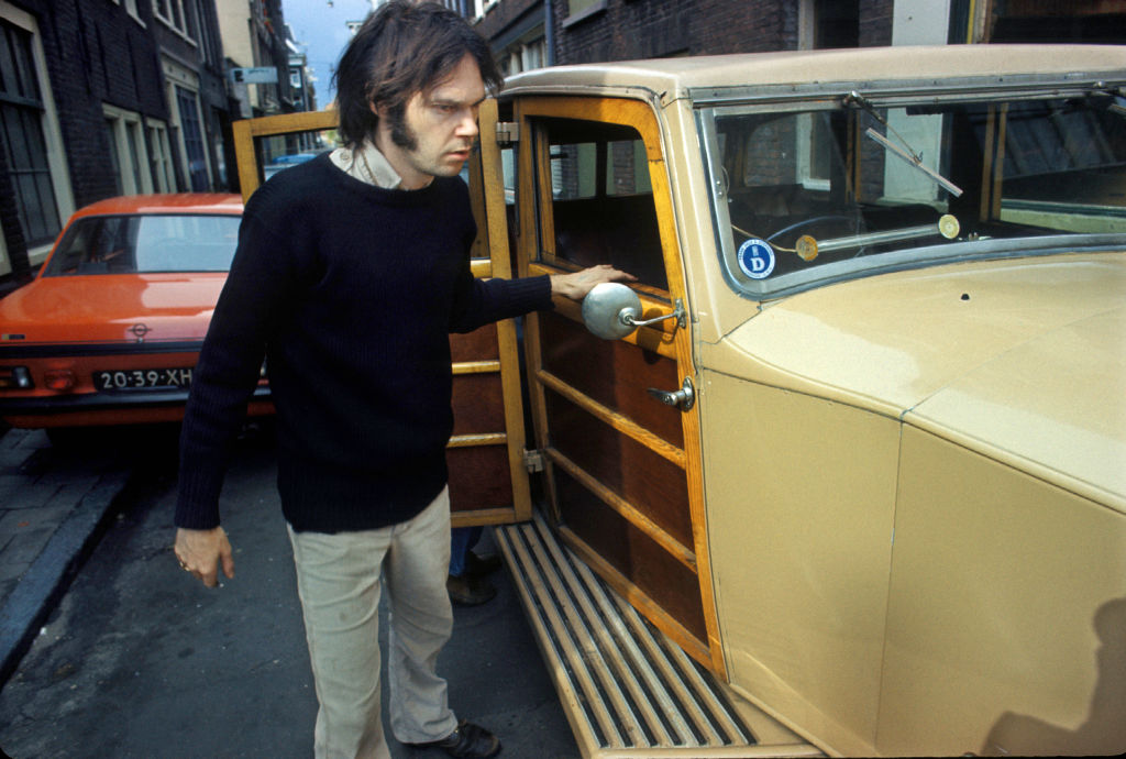 Neil Young checks over The Rolls Royce car he has just purchased in Jordaan, Amsterdam, Netherlands in 1974