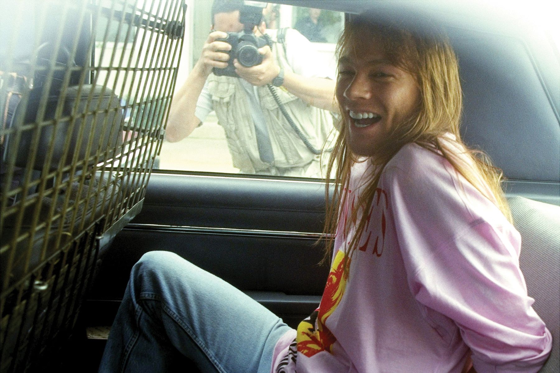 Guns N' Roses lead singer Axl Rose sits handcuffed in the back of a police car after he was arrested at Kennedy Airport upon his return from a European concert tour. Rose was charged with four counts of misdemeanor assault and one count of property damage stemming from a riot during a concert in 1991 in St. Louis