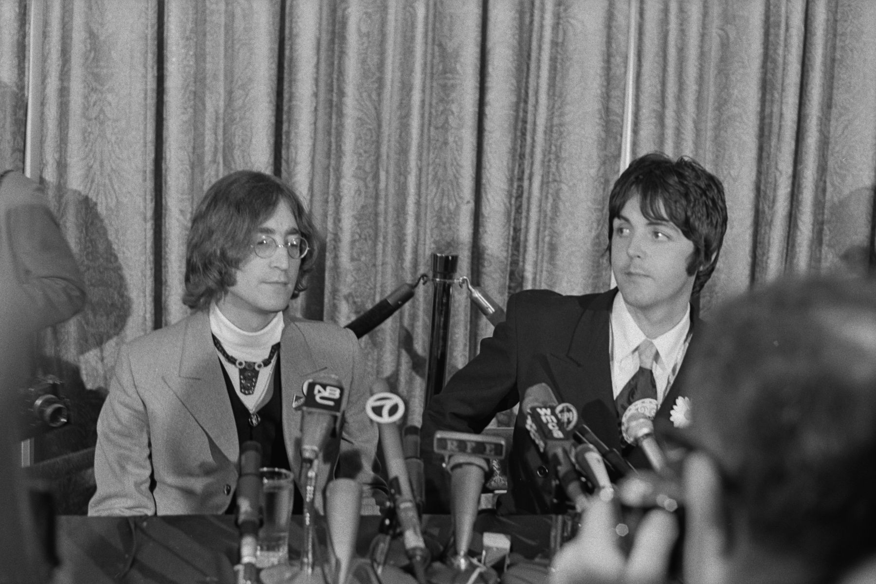 Musicians John Lennon (left) and Paul McCartney of the Beatles hold a press conference at the Americana Hotel in New York City to announce their new venture, Apple Corps, 14th May 1968
