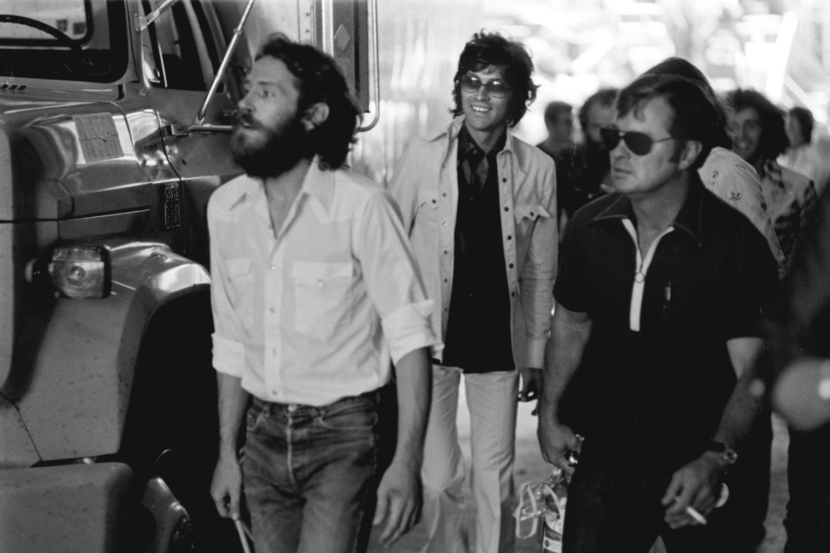 Levon Helm (left) and Robbie Robertson (centre) of The Band, backstage at a Crosby, Stills, Nash and Young concert in Oakland, California, 1974