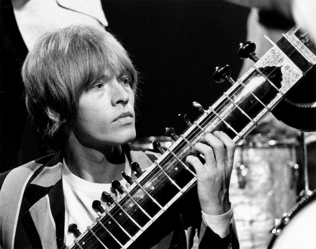 Brian Jones (1942-1969) of The Rolling Stones plays a sitar during a performance by the band on the set of the Associated Rediffusion Television pop music television show Ready Steady Go! at Wembley Television Studios in London on 27th May 1966. The group would perform three tracks on this edition of the show, 'I Am Waiting', 'Under My Thumb' and 'Paint It Black'.
