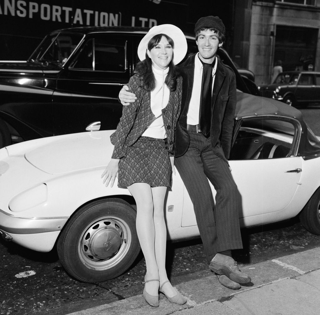 Paul Atkinson, Zombie guitarist, with his fiancee, American dancer Molly Molloy, leaning on his Lotus Elan, London, 15th September 1967