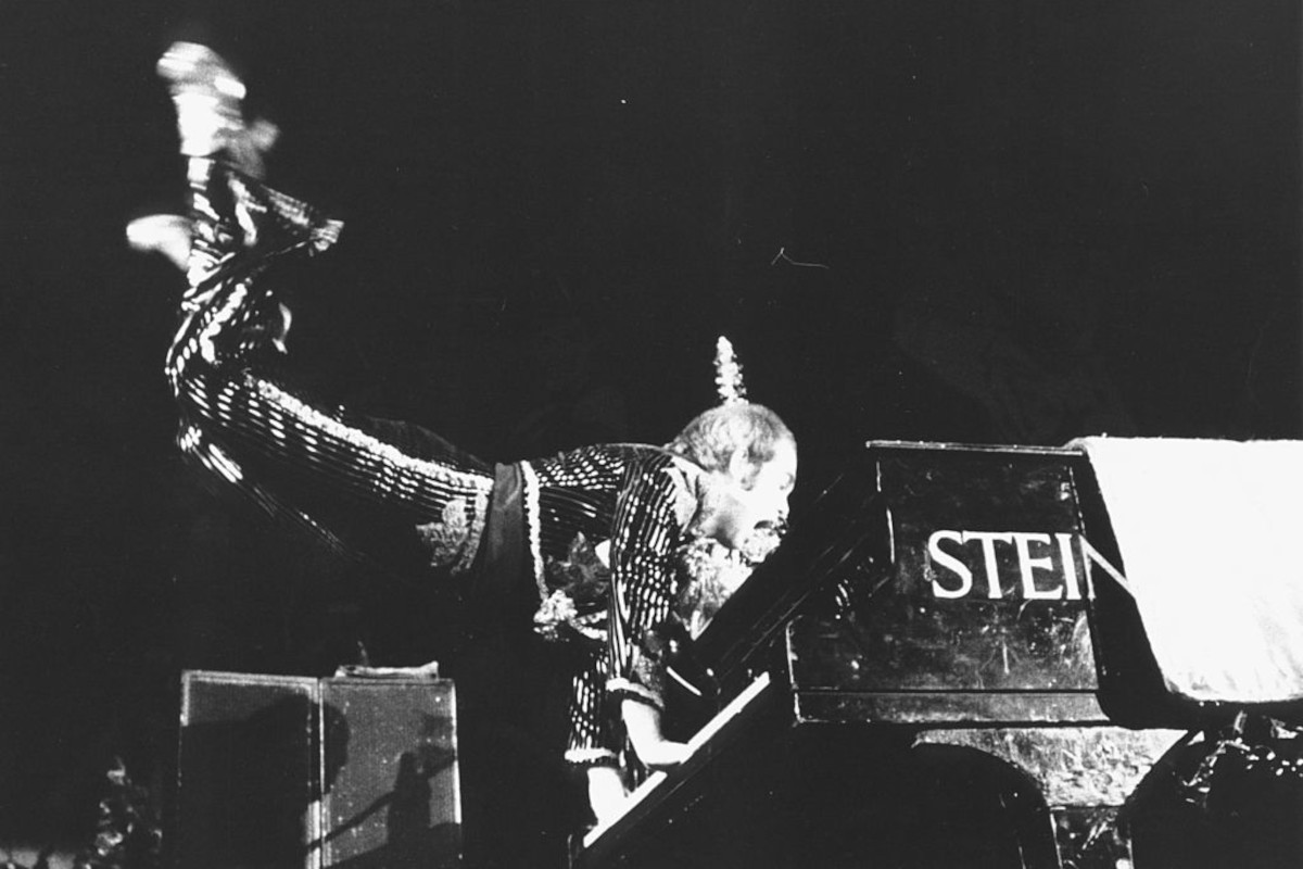 Elton John performing one of his patented piano handstand party tricks, circa 1974