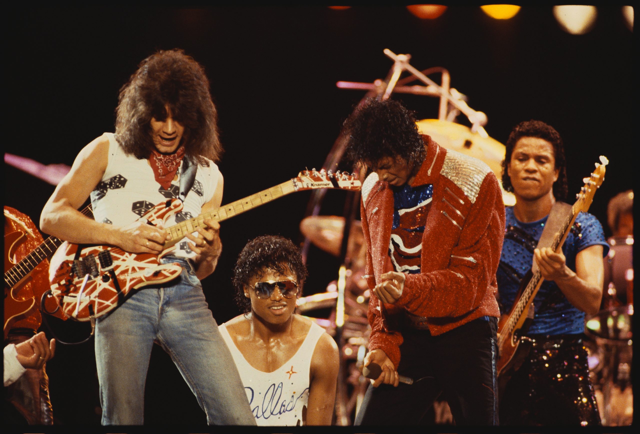 Eddie Van Halen plays guitar on stage with Randy Jackson, Michael Jackson and Jermaine Jackson during the Victory Tour