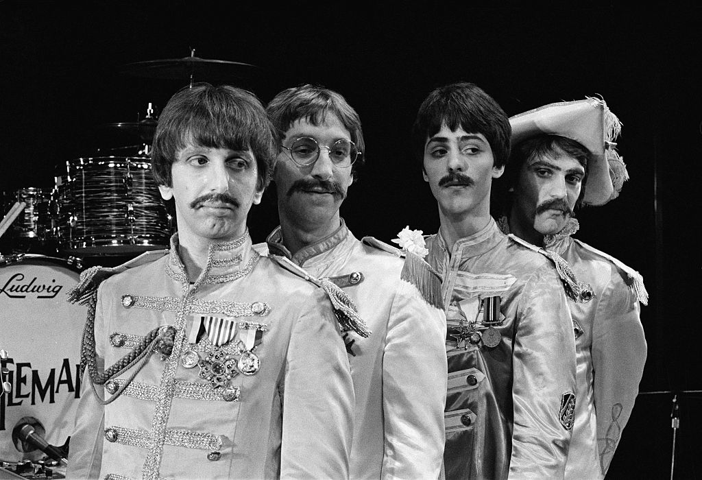 Actors (left to right) Jack Lee Elggod, Neil Harrison, David Birch and Andre Barreau pose for a group photo as The Beatles in Sergeant Pepper's-era stage costume to promote the musical 'Beatlemania', London, December 5 1979