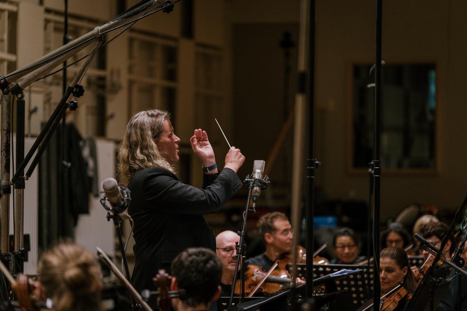 Nathan Henninger conducting an orchestra in the recording studio