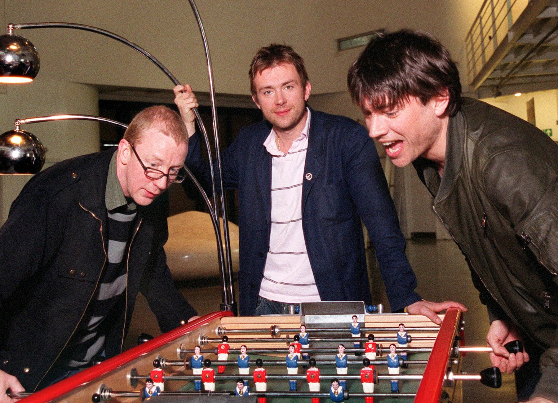 Dave Rowntree, Damon Albarn and Alex James of Blur enjoying a spot of table football, 2003
