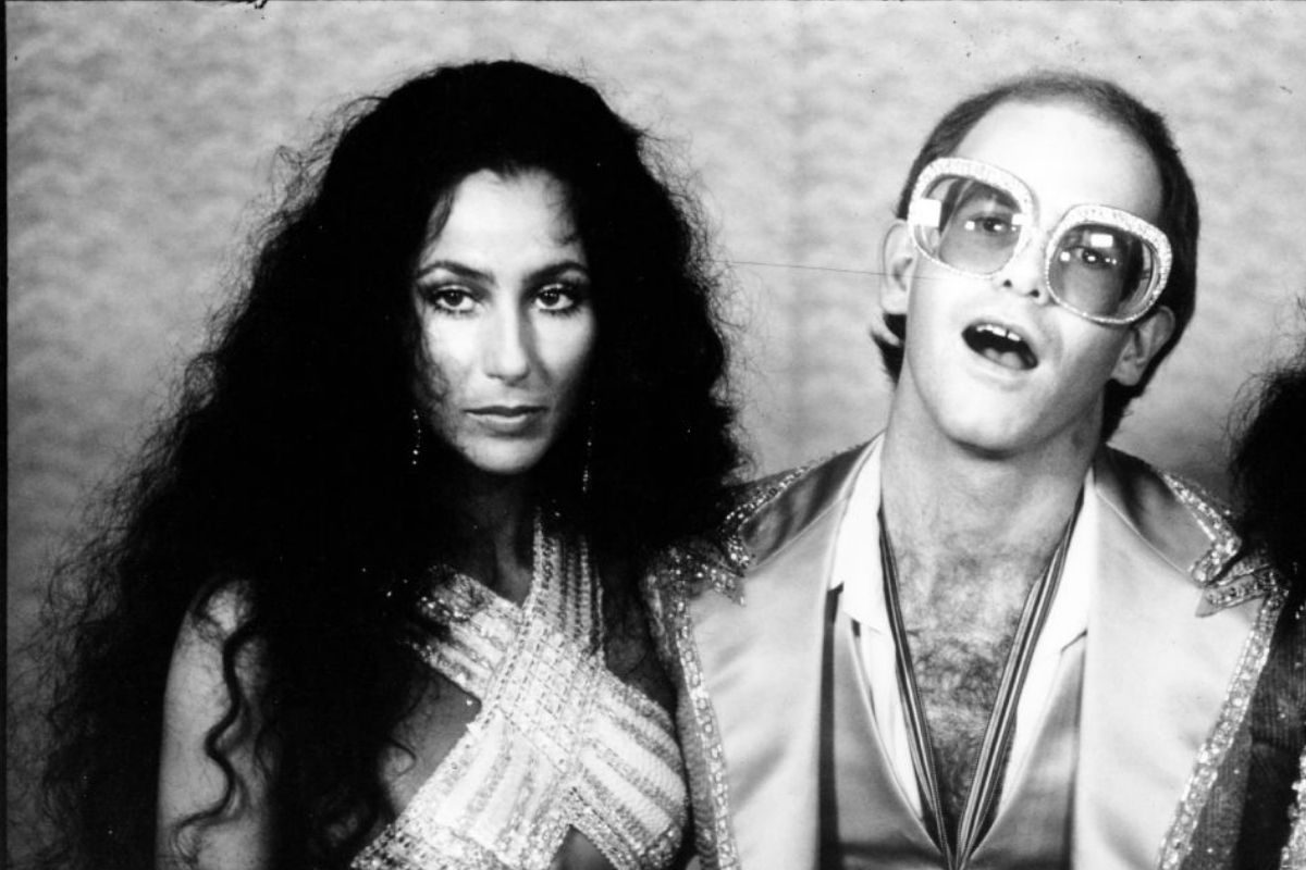 Elton John backstage at an awards show with Cher, 1975