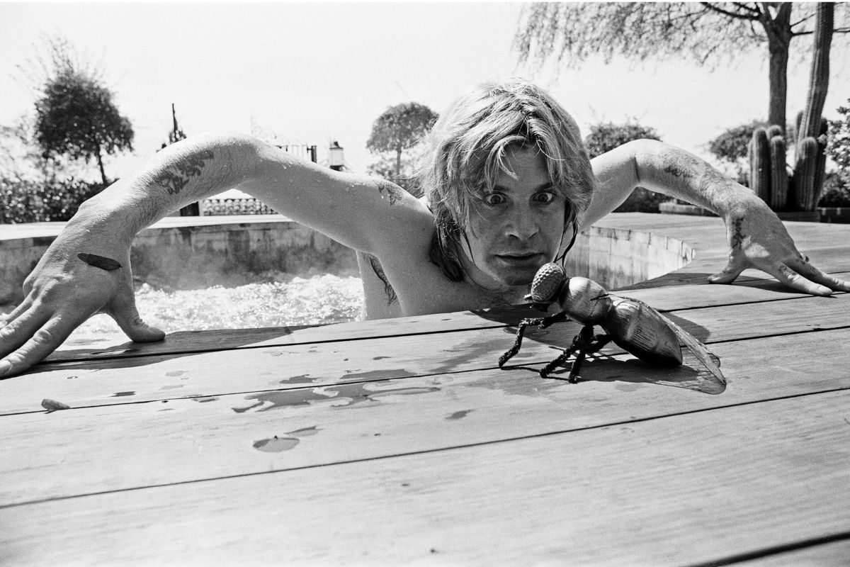 Ozzy Osbourne, former lead singer of Black Sabbath, pictured in his open air hot tub in the garden of his luxury home in Goldwater Canyon, Beverly Hills, California with giant rubber fly. 28th April 1982