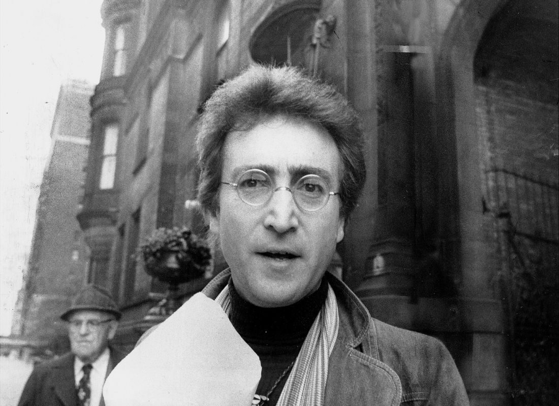 John Lennon returning from a florist shop, outside his apartment at the Dakota, May 1976