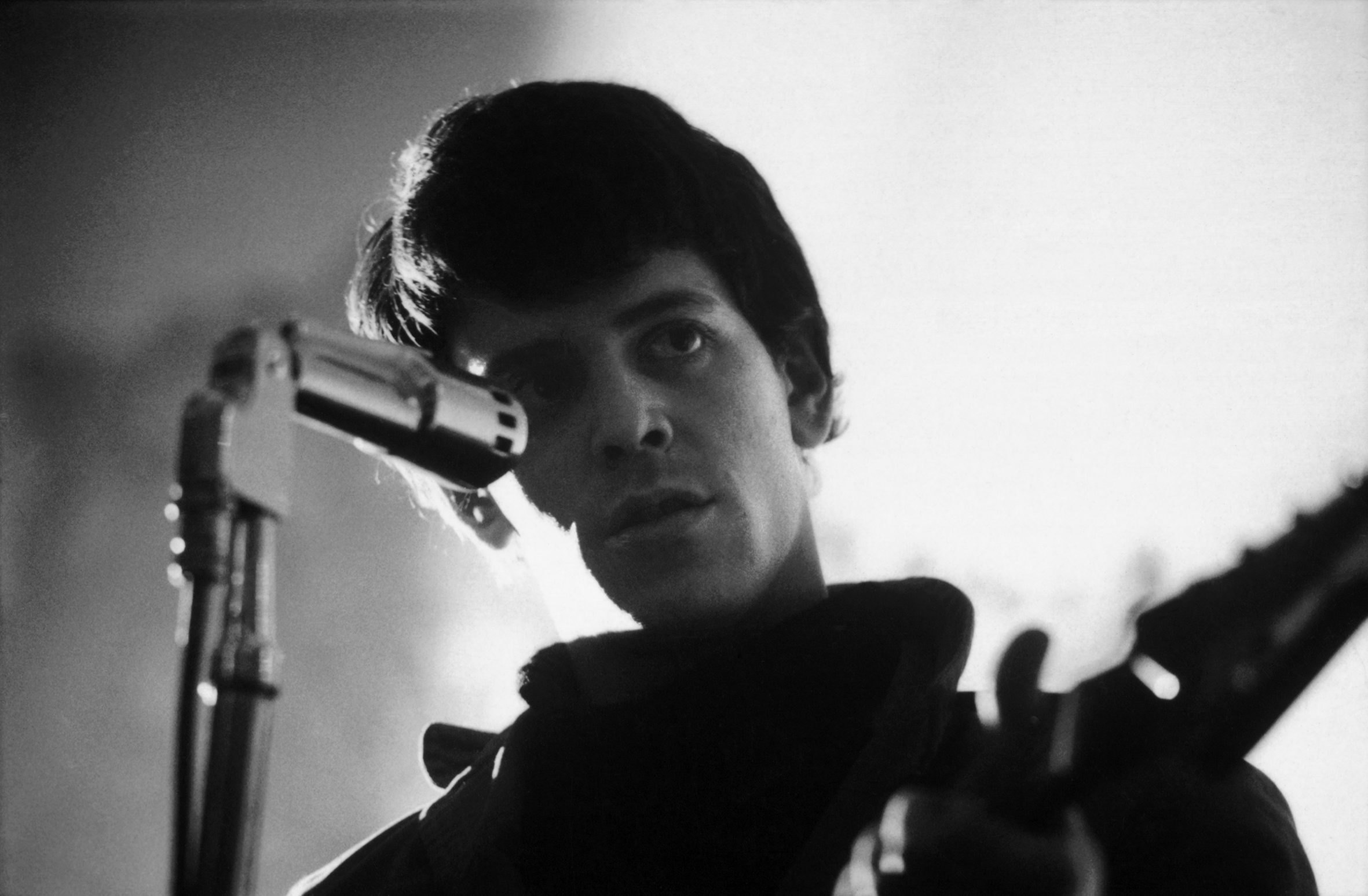 Black and white photo of Lou Reed of the Velvet Underground performs on stage, 1966