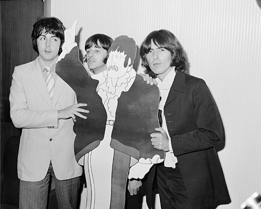 The Beatles Paul McCartney, Ringo Starr and George Harrison with a cardboard cut out of John Lennon from the film Yellow Submarine. July 1968.
