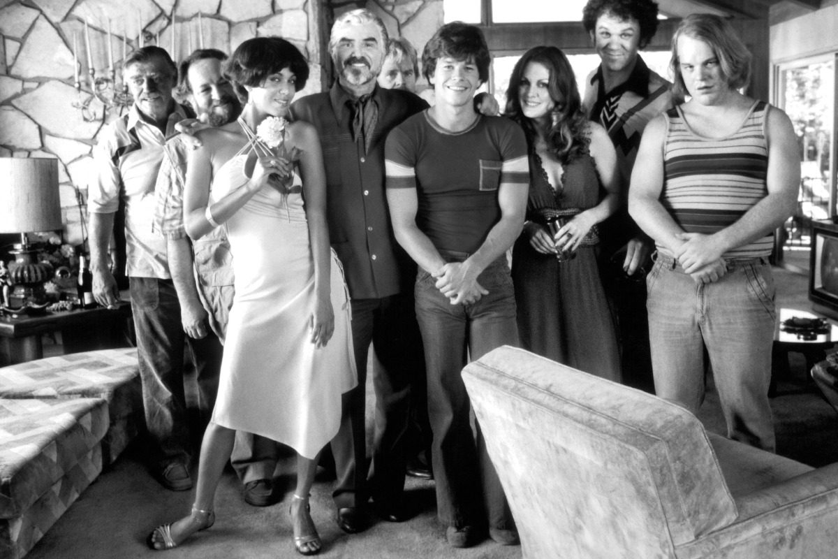 (L-R) Jack Wallace, Rickey Jay Nicole, Ari Parker, Burt Reynolds, William H Macy, Mark Wahlberg, Julianne Moore, John C. Reilly and Phillip Seymour Hoffman pose on set of the movie "Boogie Nights " , circa 1997