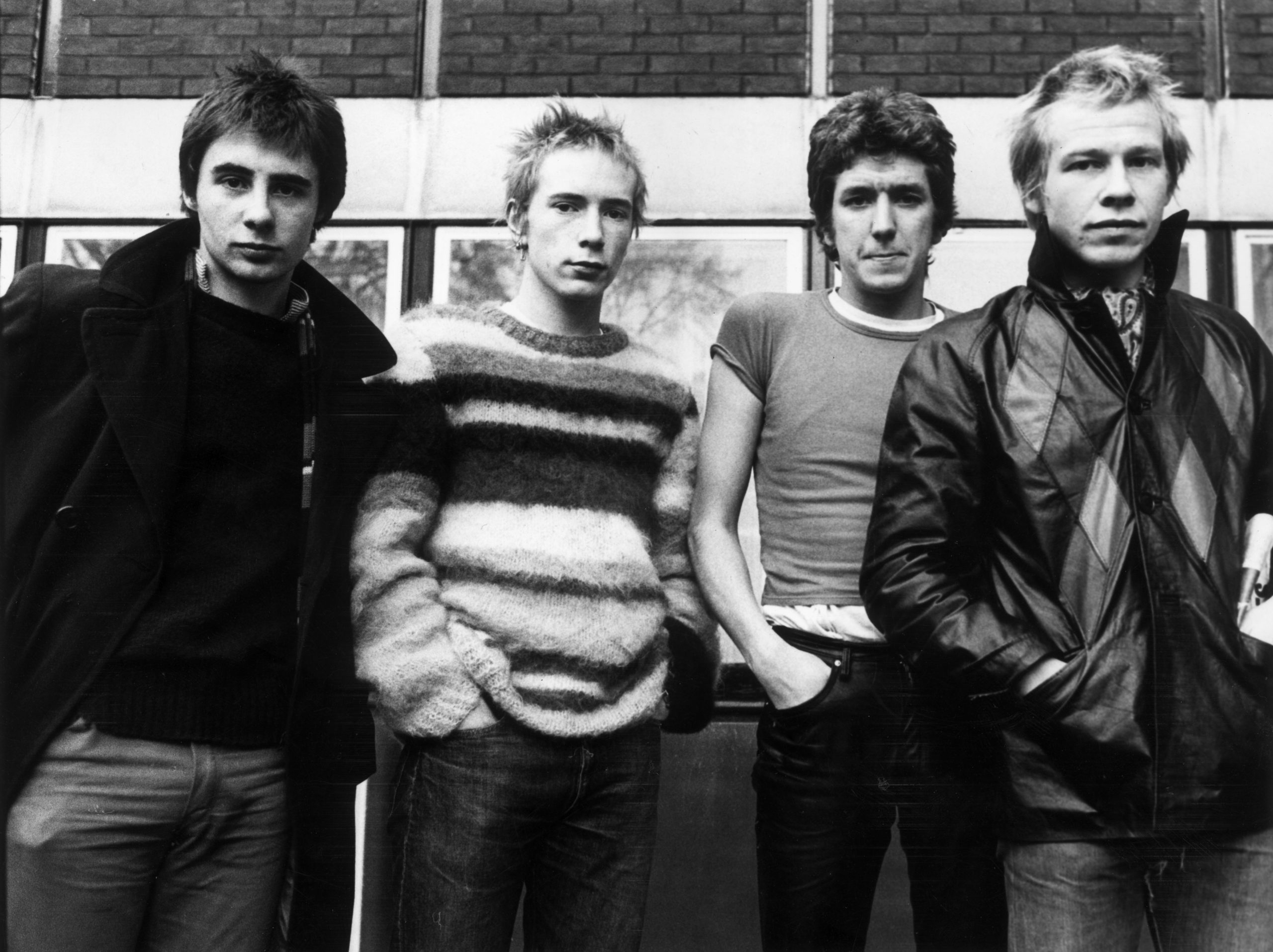 Black and white photo of the Sex Pistols against a wall