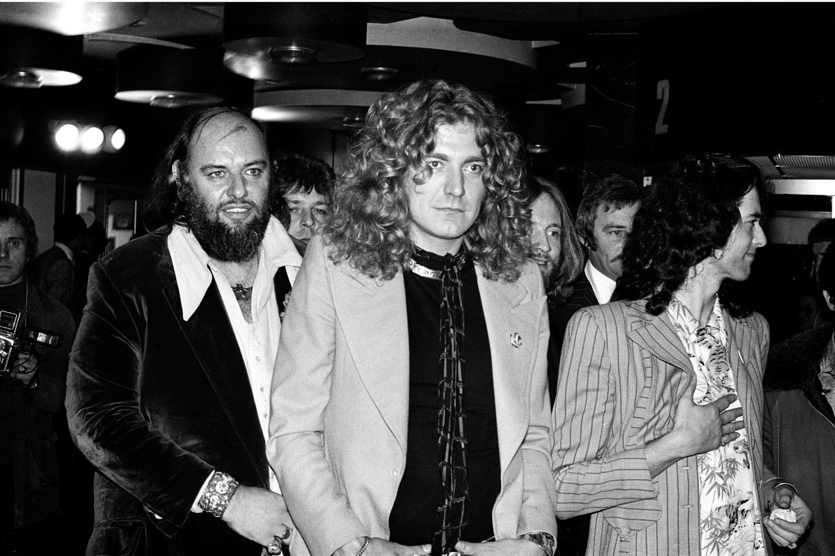 Rock band Led Zeppelin at the UK premier of the concert film 'The Song Remains The Same'. Pictured from left to right, manager Peter Grant, Robert Plant and Jimmy Page, 4th November 1976