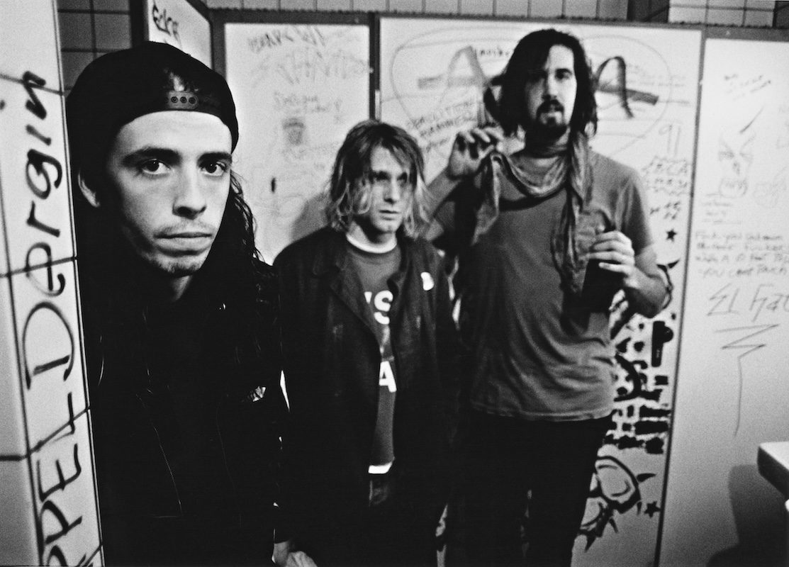Black and white photo of American rock group Nirvana, backstage in Frankfurt, Germany, 12th November 1991. Left to right: drummer Dave Grohl, singer and guitarist Kurt Cobain. With graffiti bathroom backdrop