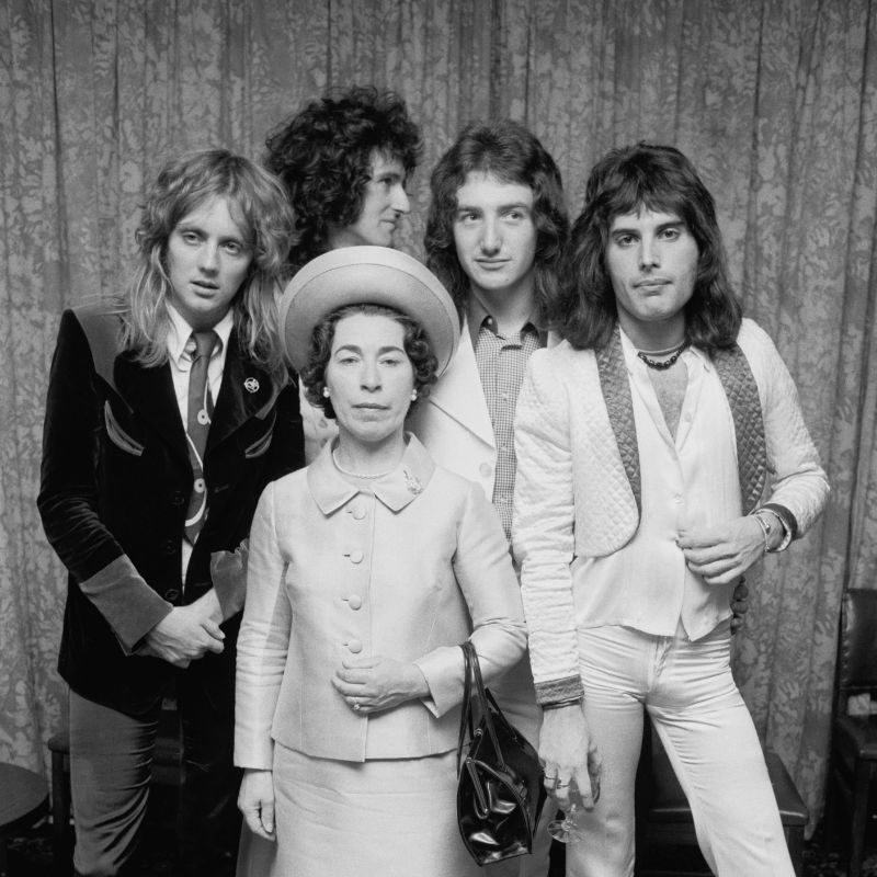 British rock band Queen posing with actress and Queen Elizabeth II look-alike, Jeannette Charles, September 1974.