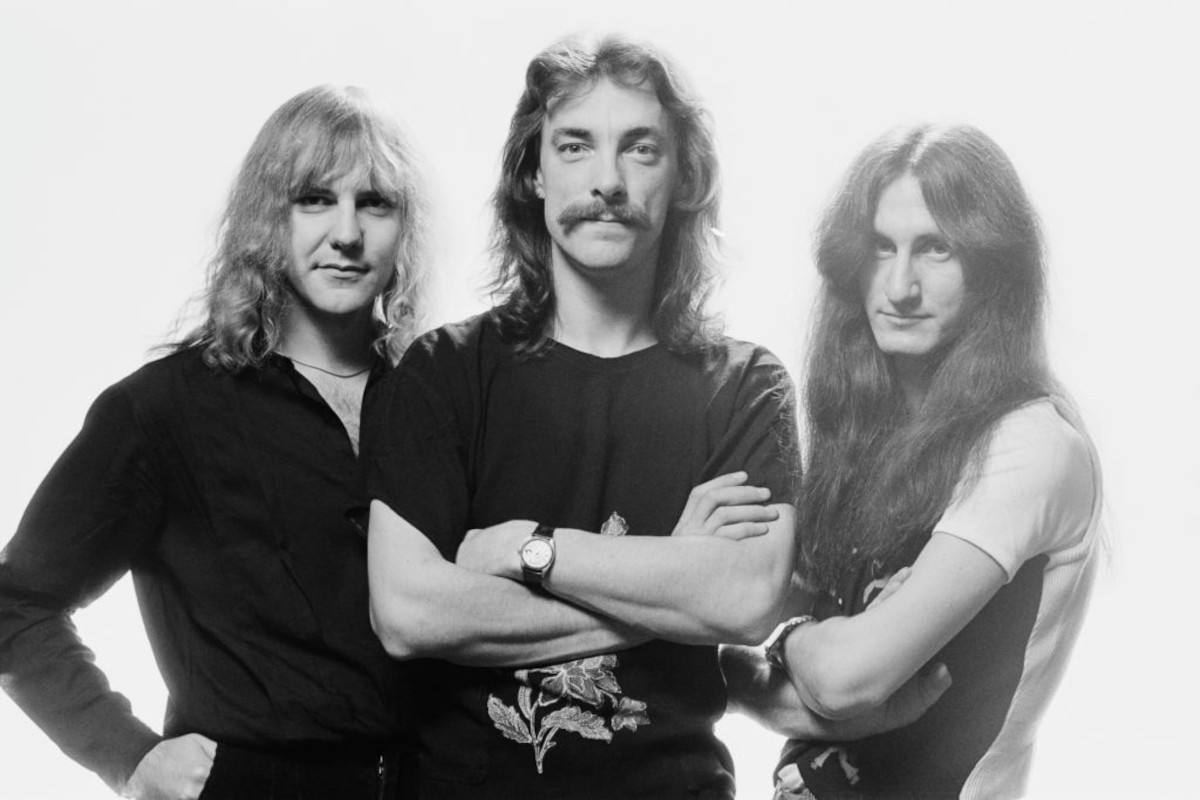 Rush (Alex Lifeson, Neil Peart and Geddy Lee), posing for a group portrait, against a white background, United Kingdom, in May 1979