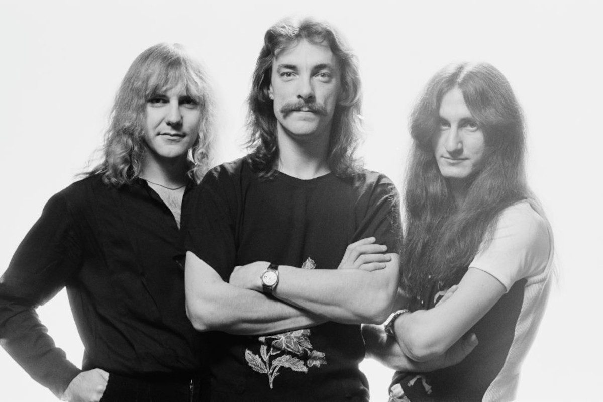 Rush (Alex Lifeson, Neil Peart and Geddy Lee), posing for a group portrait, against a white background, United Kingdom, in May 1979