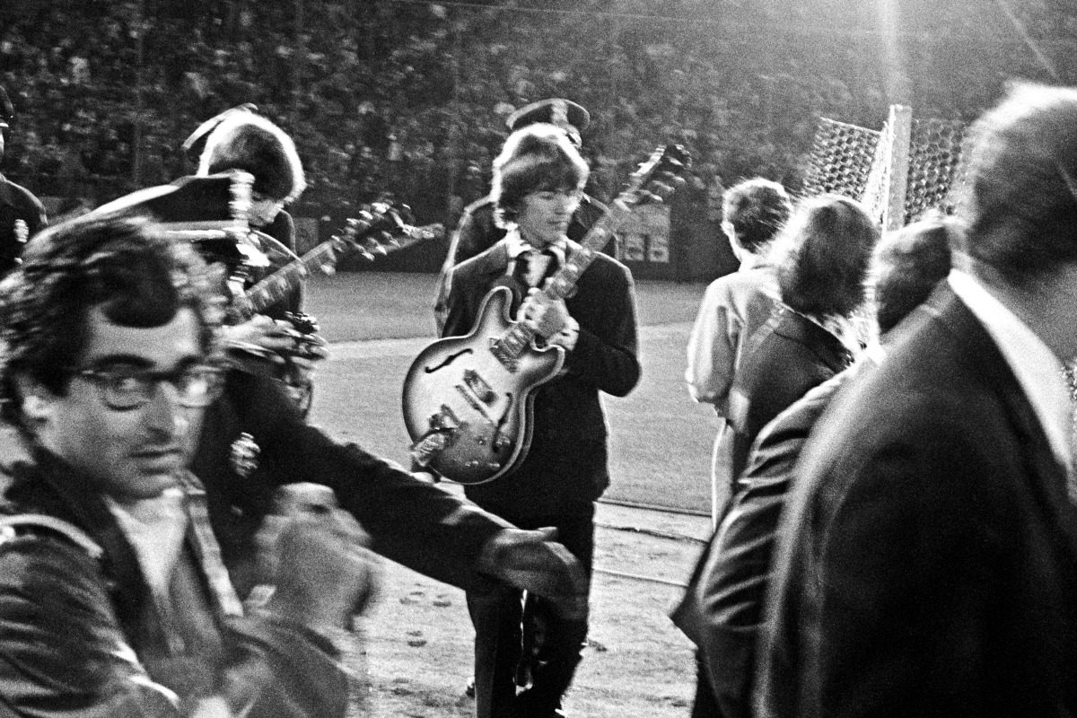 George Harrison and Ringo Starr (partially obscured) walk onto the infield of Candlestick Park, their last public concert, 29 August 1966