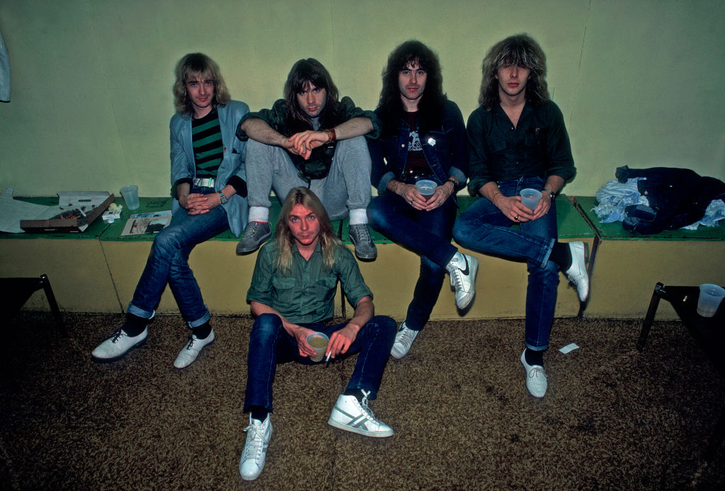 Portrait of British heavy metal band Iron Maiden backstage at the Rosemont Horizon during their Beast on the Road Tour, Chicago, Illinois, September 21, 1982. Pictured are, from left, Adrian Smith, Bruce Dickinson, Dave Murray (on floor), Steve Harris, and Clive Burr