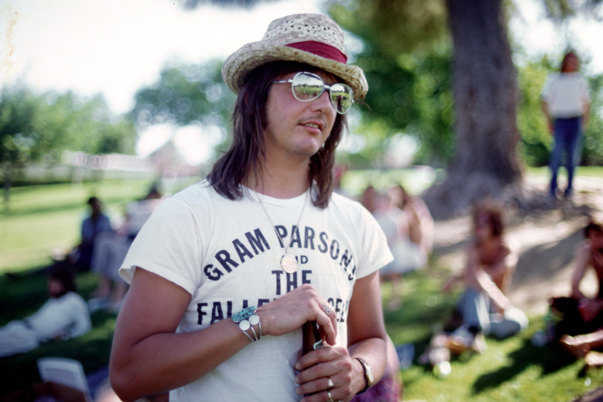Singer/songwriter Gram Parsons wears a Gram Parsons and the Fallen Angels T-shirt at a party in the park in June 1973 in Los Angeles, California.