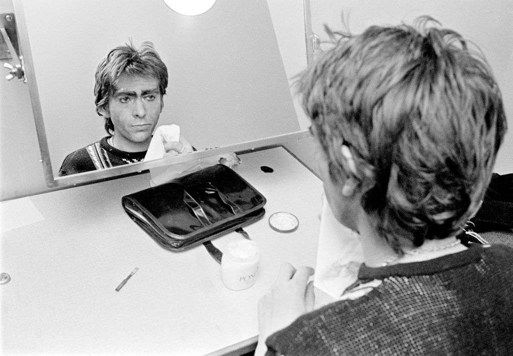 Peter Gabriel backstage in dressing room doing his make-up for The Lamb Lies Down On Broadway Tour, Denmark, 1975