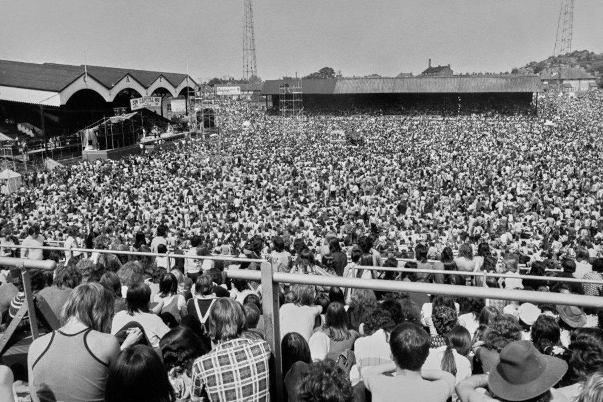 A large crowd watching a band perform at the Summer of '74 concert, Charlton