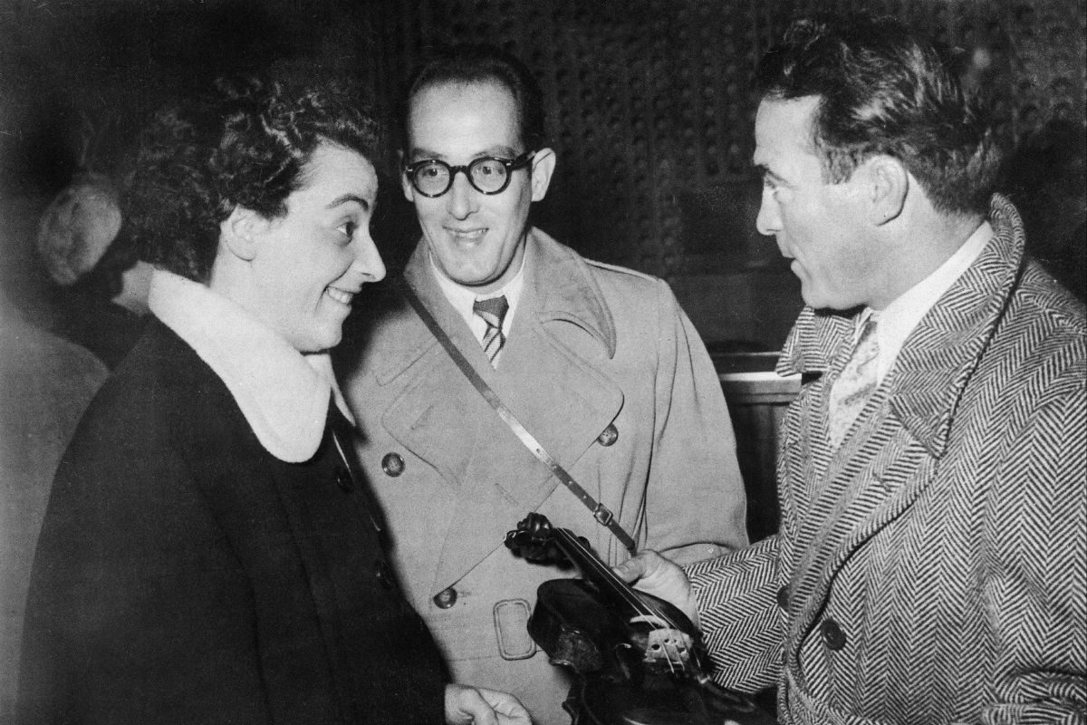 The violinist Ginette Neveu showing one of her Stradivarius violins to boxer Marcel Cerdan at Orly on October 27, 1949, a few minutes before boarding the plane that would crash, killing all three