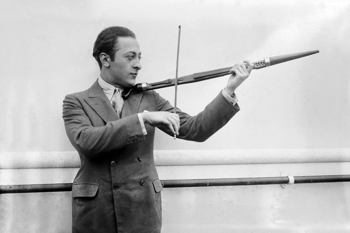 Violinist Jascha Heifetz playing an unusual violin that doubles as a walking stick