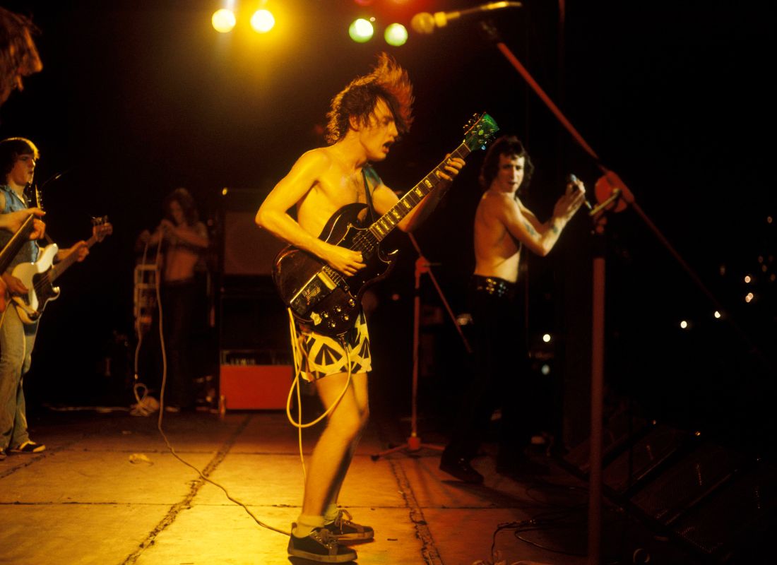 Early AC/DC onstage. L-R: Mark Evans, Angus Young, Bon Scott