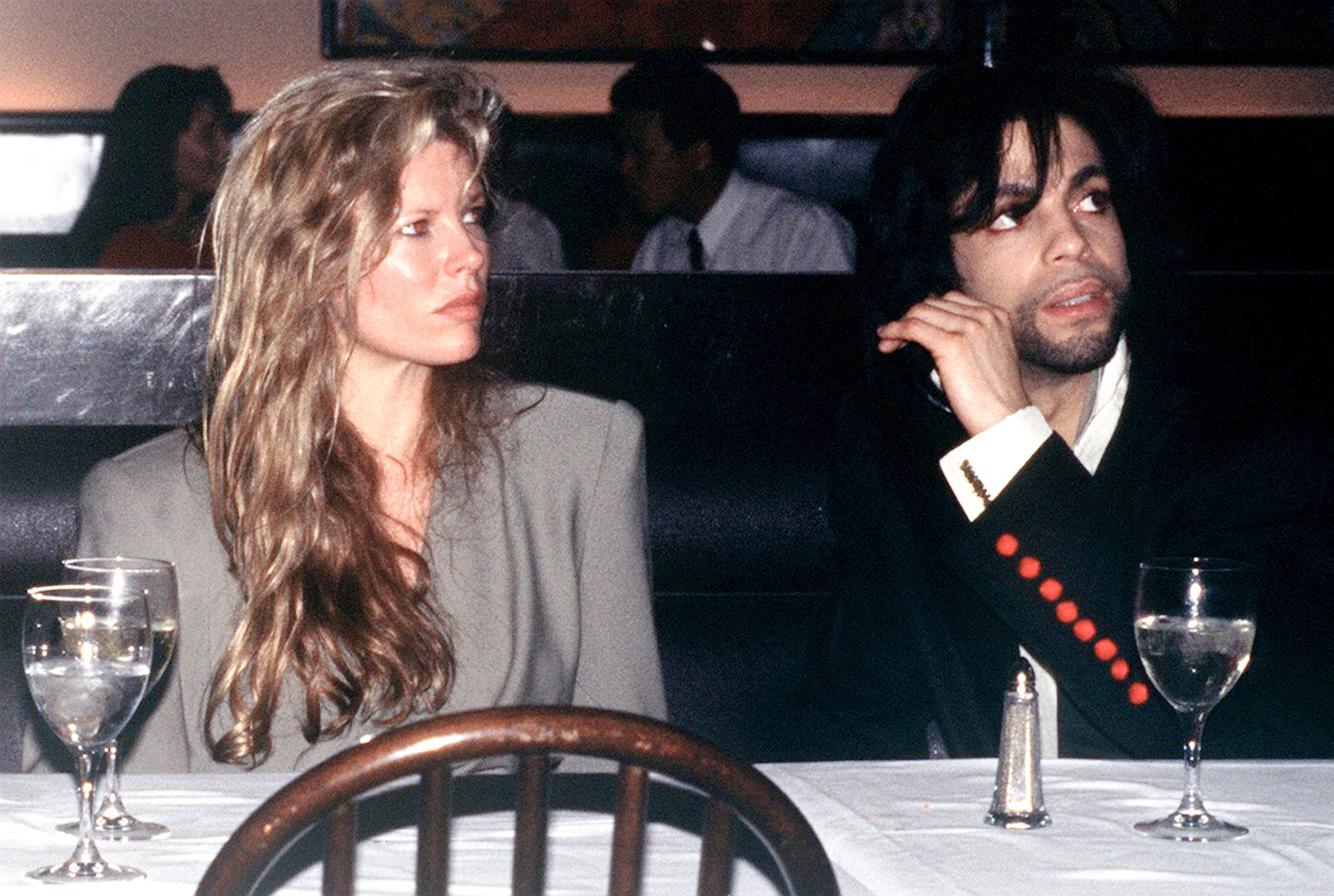 American film actress Kim Basinger with singer Prince, circa 1988, sitting at a dining table 