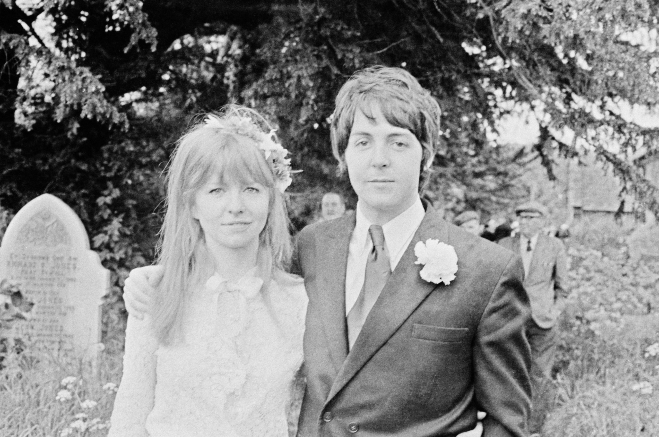 Black and white photo of Paul McCartney and Jane Asher pose together outside the church in Caerog, North Wales during the wedding of his brother Mike McGear 