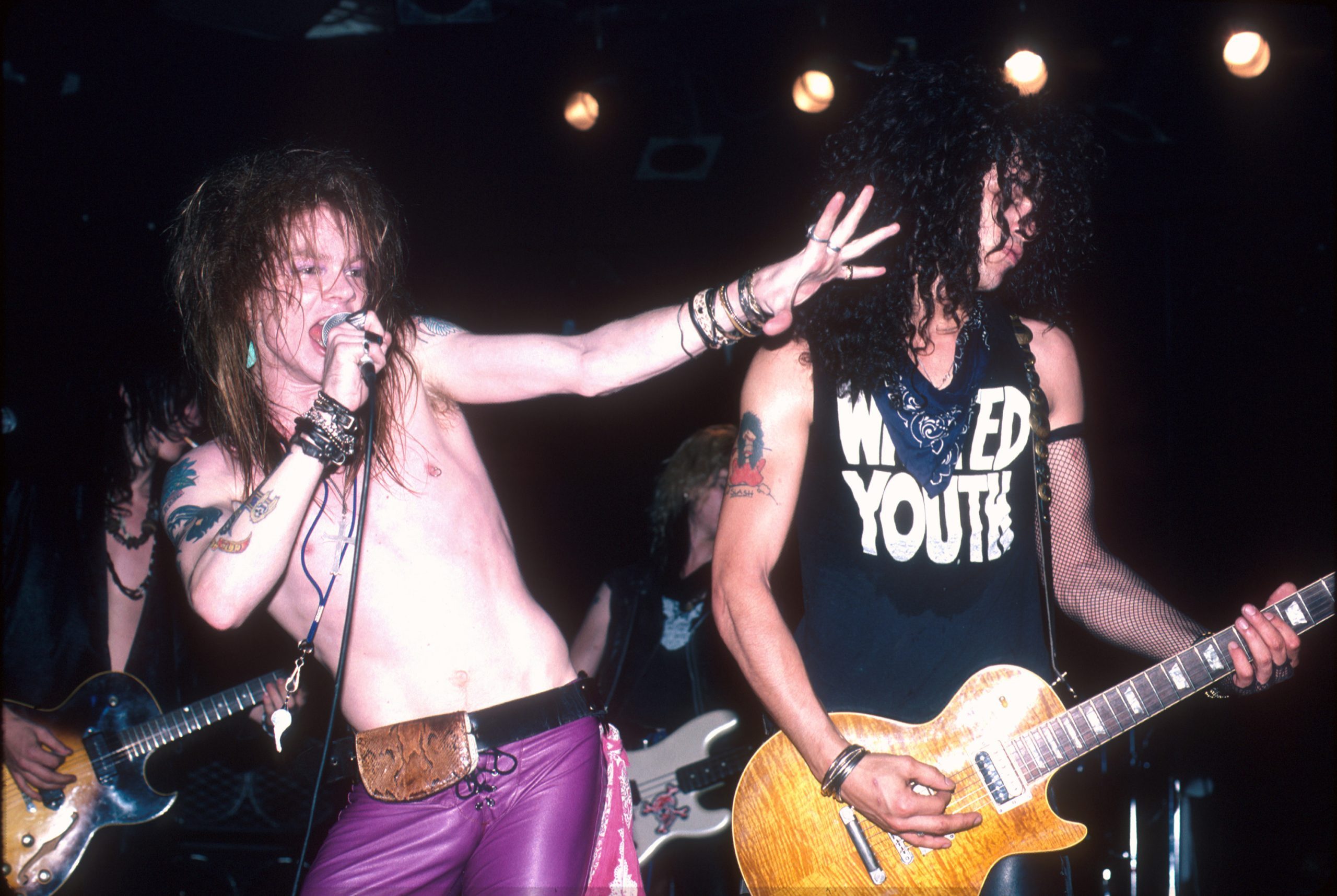 Axl Rose and Slash of Guns N' Roses performing on stage, Axl Rose performing shirtless