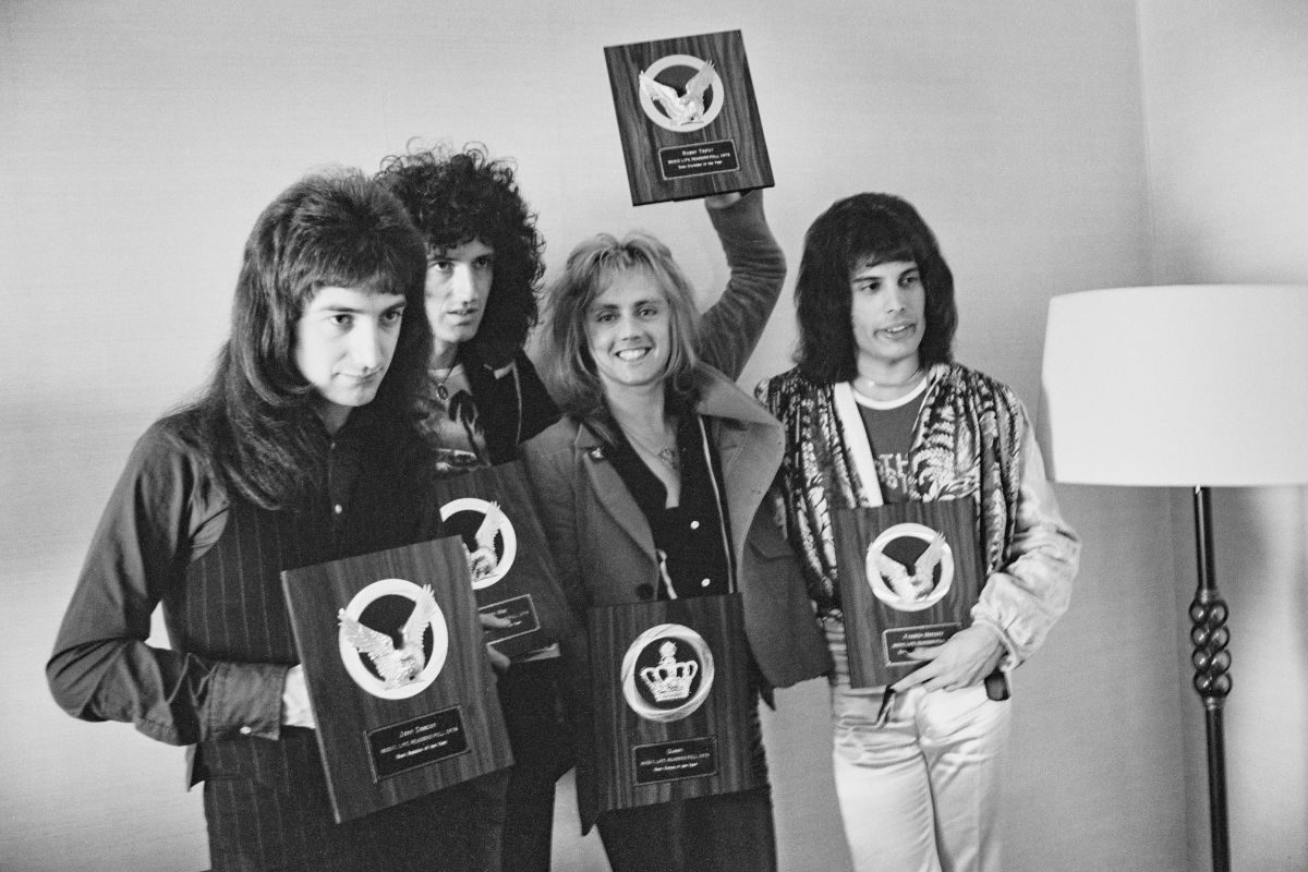Queen holding their awards for topping the popularity poll in Japanese music magazine Music Life, Tokyo, Japan, 18th April 1975. L-R John Deacon, Brian May, Roger Taylor, Freddie Mercury