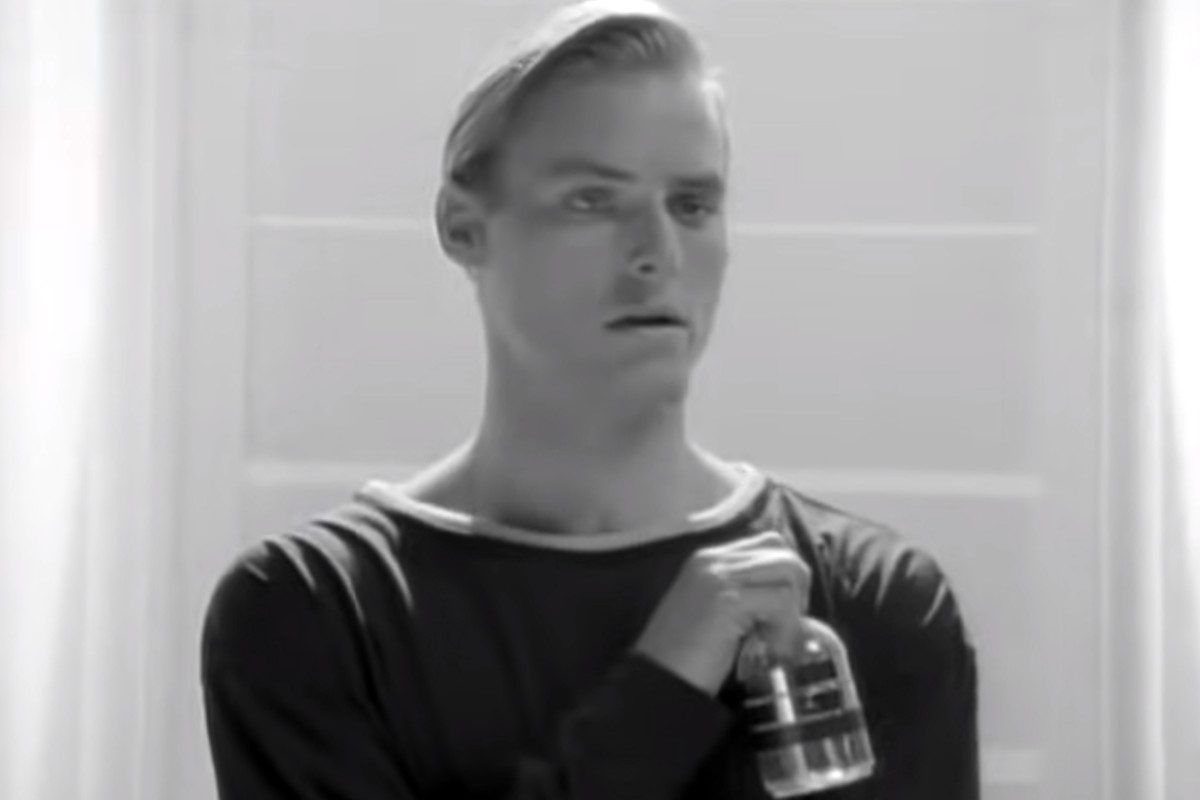 Still of a person holding a glass bottle from Neil Young's 'This Note's For You' music video