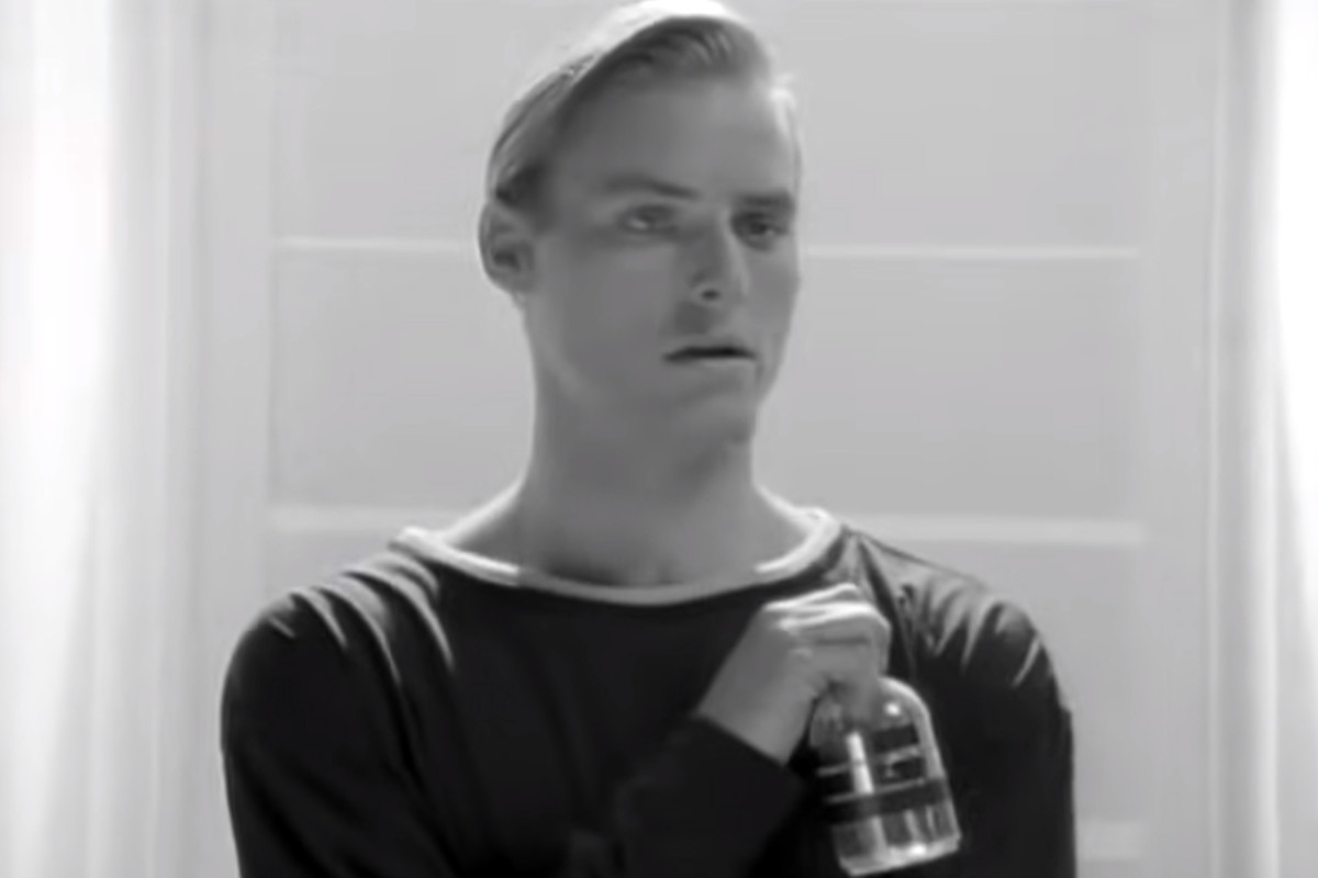 Still of a person holding a glass bottle from Neil Young's 'This Note's For You' music video