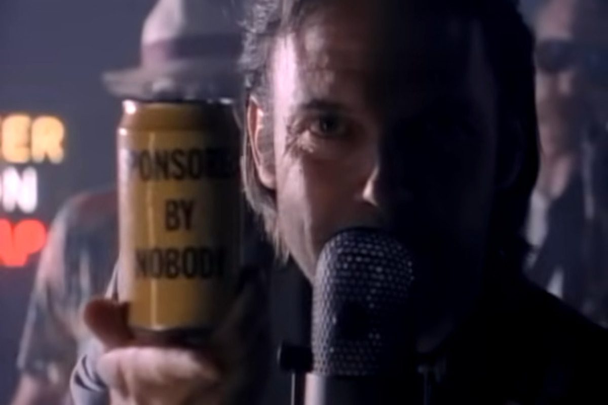 Neil Young, sponsored by nobody on a can he's holding up. A still from his 'This Note's For You' music video