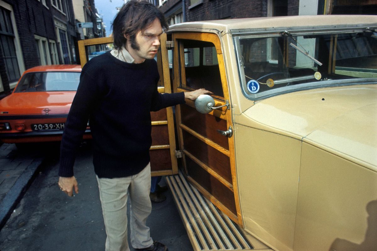 Neil Young checks over The Rolls Royce car he has just purchased in Jordaan, Amsterdam, Netherlands in 1974