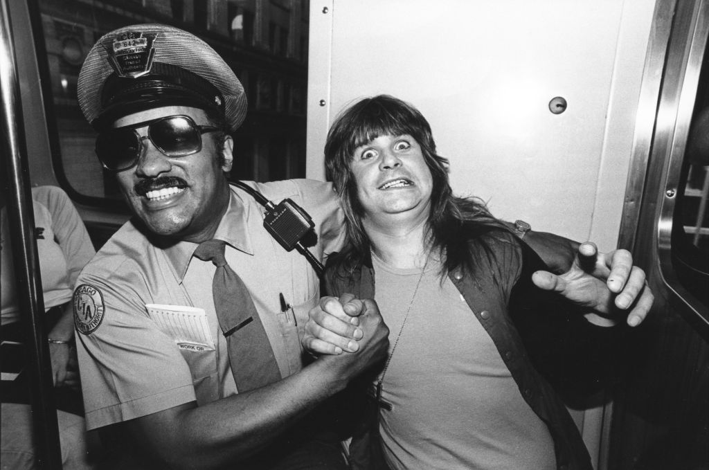 Heavy metal singer Ozzy Osbourne hams it up with a Chicago Transit Authority policeman circa 1980 in Chicago, Illinois